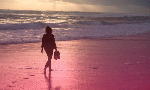 Woman strolling along the shoreline with shoes in hand, symbolizing release, trust, and peace — 'Let Go and Let God: Finding Peace in Surrender.